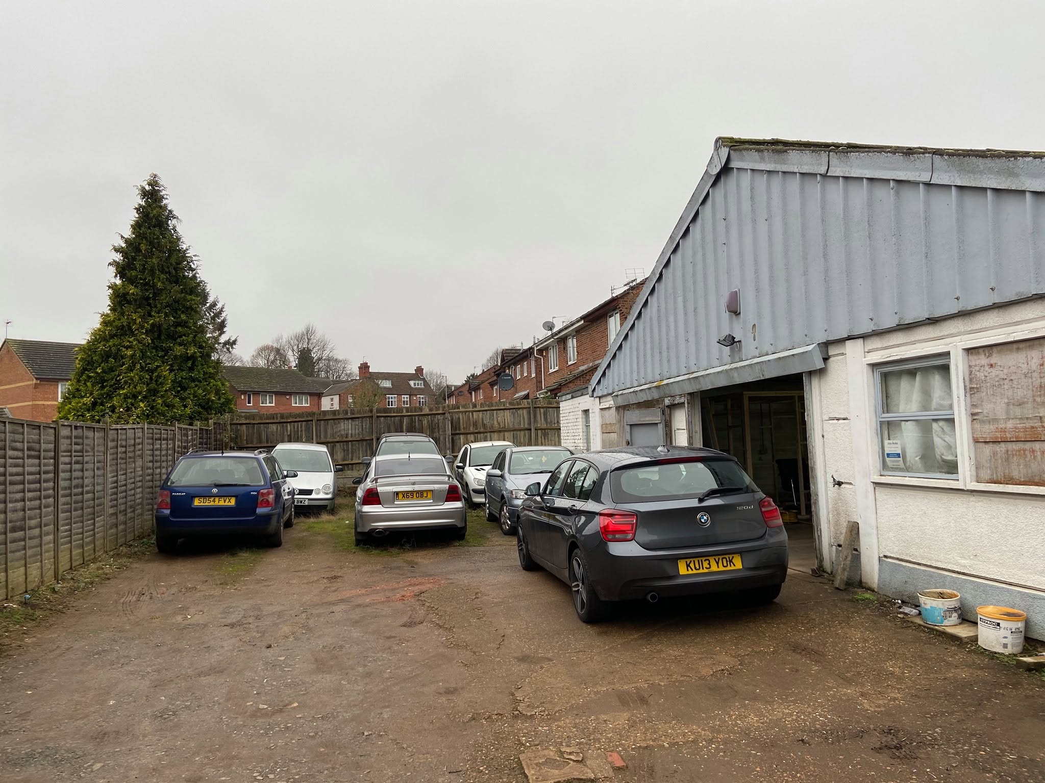 Cars waiting in the yard outside the workshop